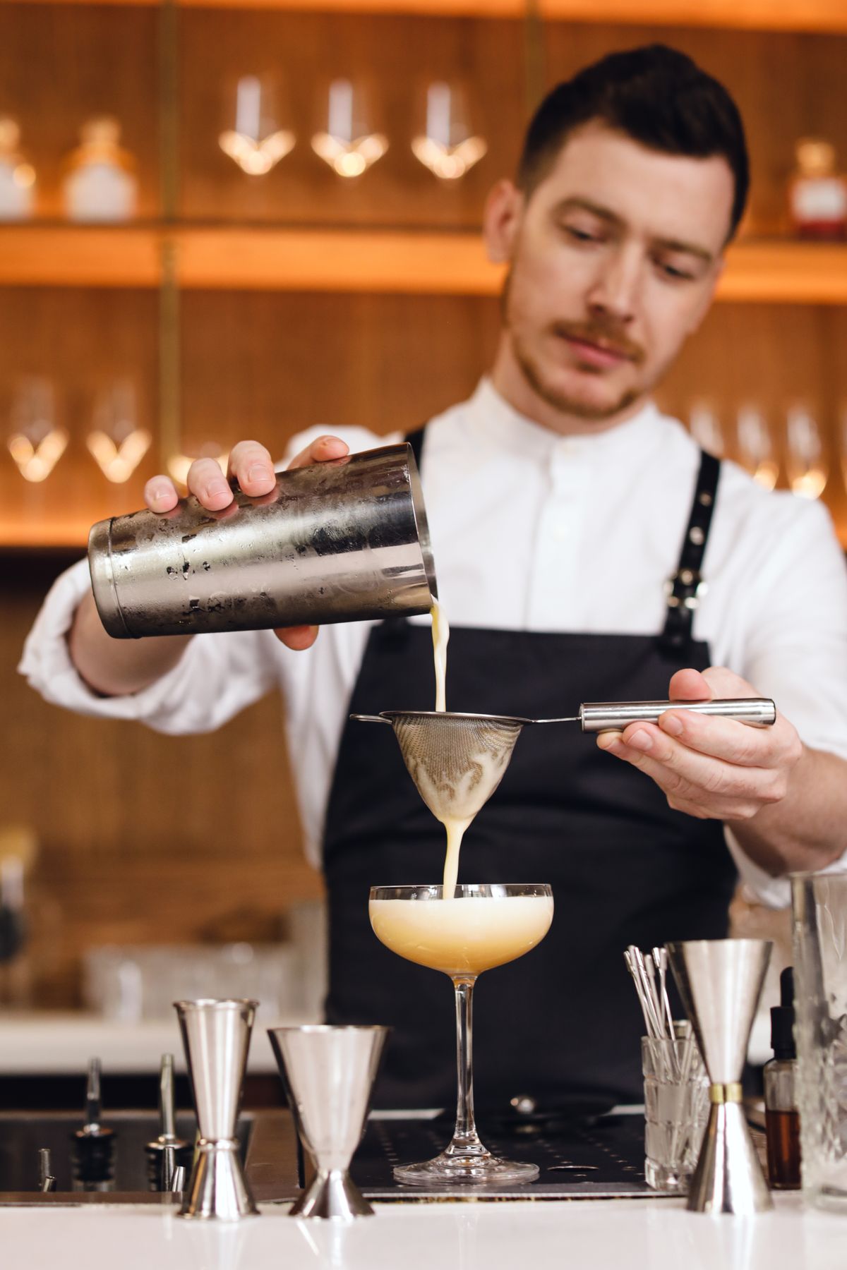 Bartender straining a craft cocktail